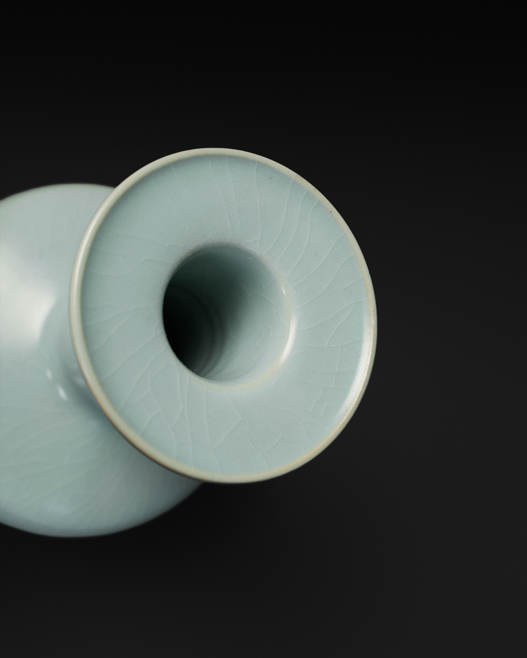 Angled close-up of the celadon vase dish mouth with a pale rim and visible crackle lines.