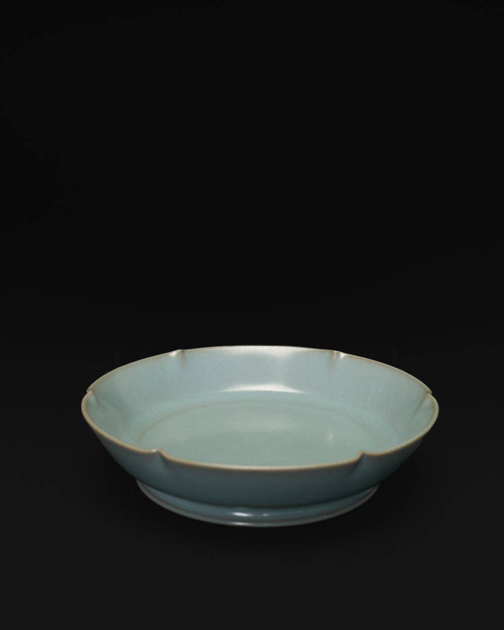 Angled front view of a celadon Chinese brush washer with a six-lobed mallow-shaped rim.