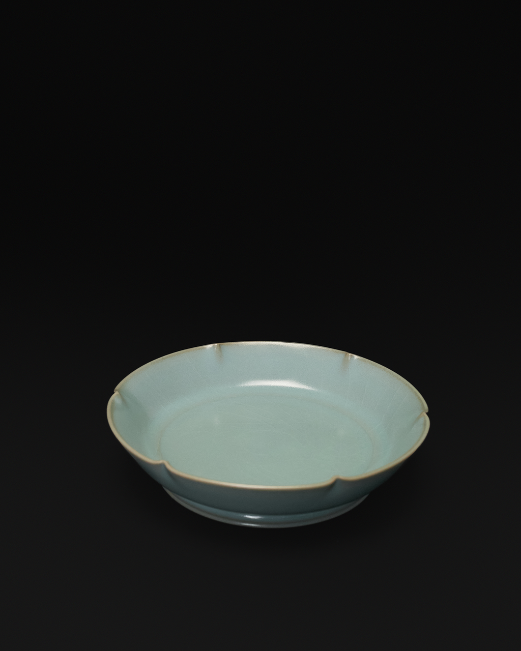 Three-quarter view of the celadon Chinese brush washer showing its lobed interior and foot ring.