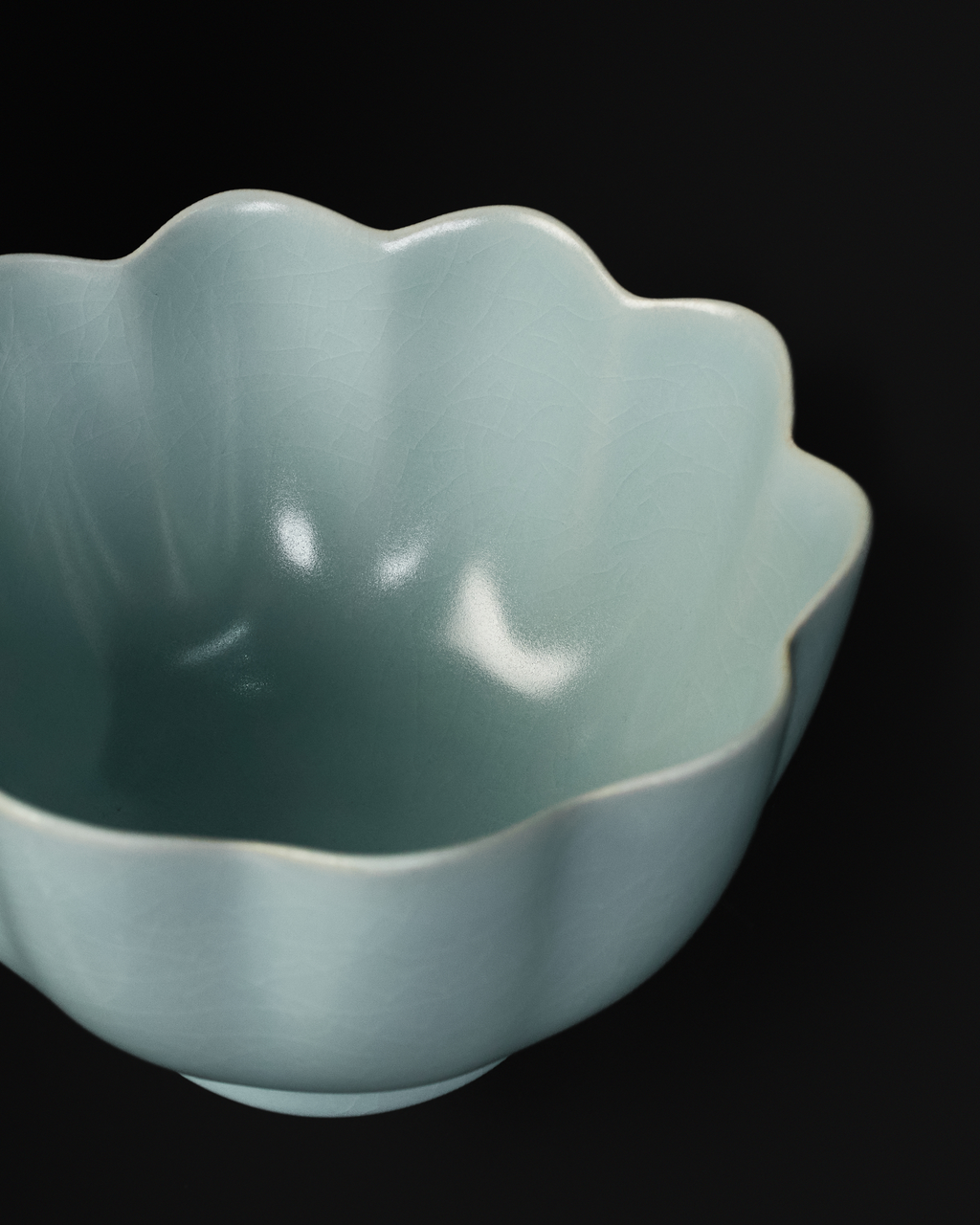 Close-up of the scalloped lotus rim and petal-shaped interior of the Chinese celadon bowl.