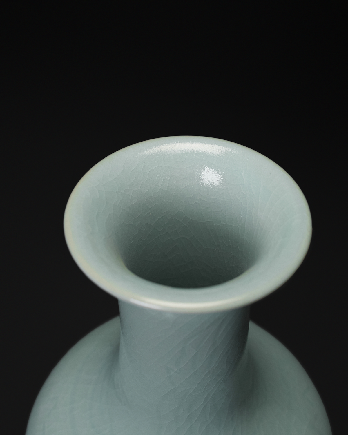 Angled top view of the vase neck and rim with visible crackle lines in the celadon glaze.