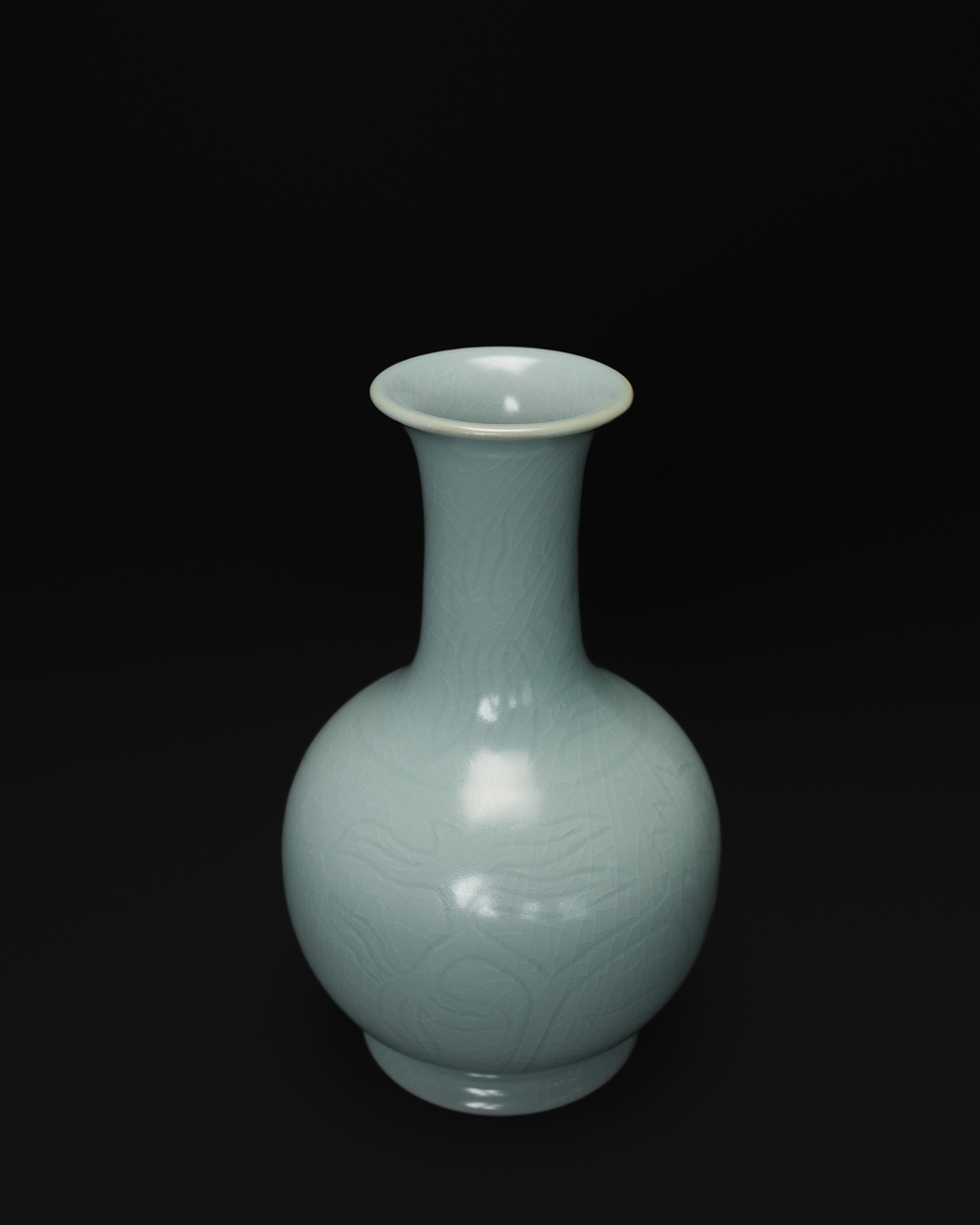 Three-quarter view of a Chinese celadon vase with a flared rim and carved decoration.