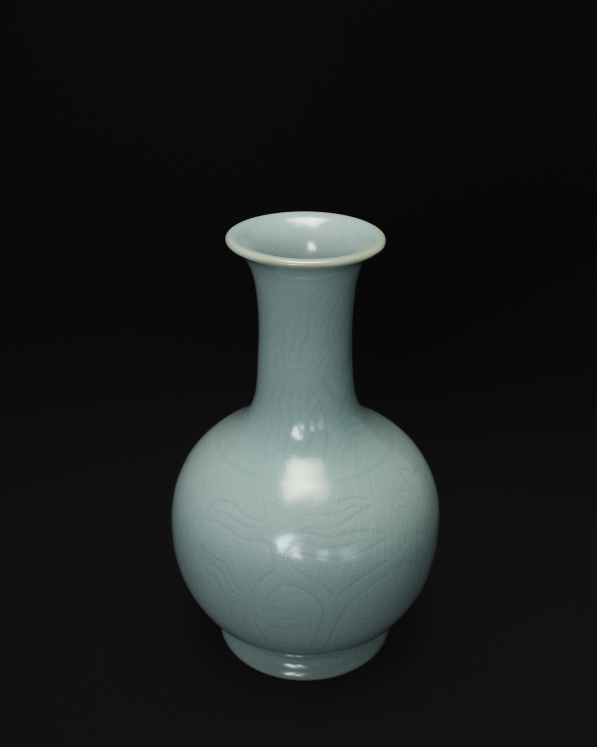 Three-quarter view of a Chinese celadon vase with a flared rim and carved decoration.