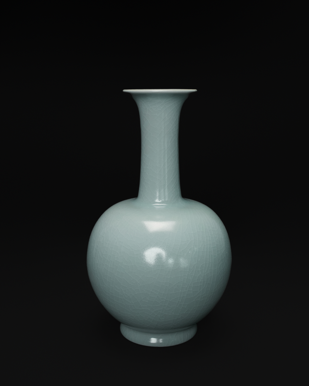 Front view of a celadon long neck vase with a flared rim, slender neck and rounded body.