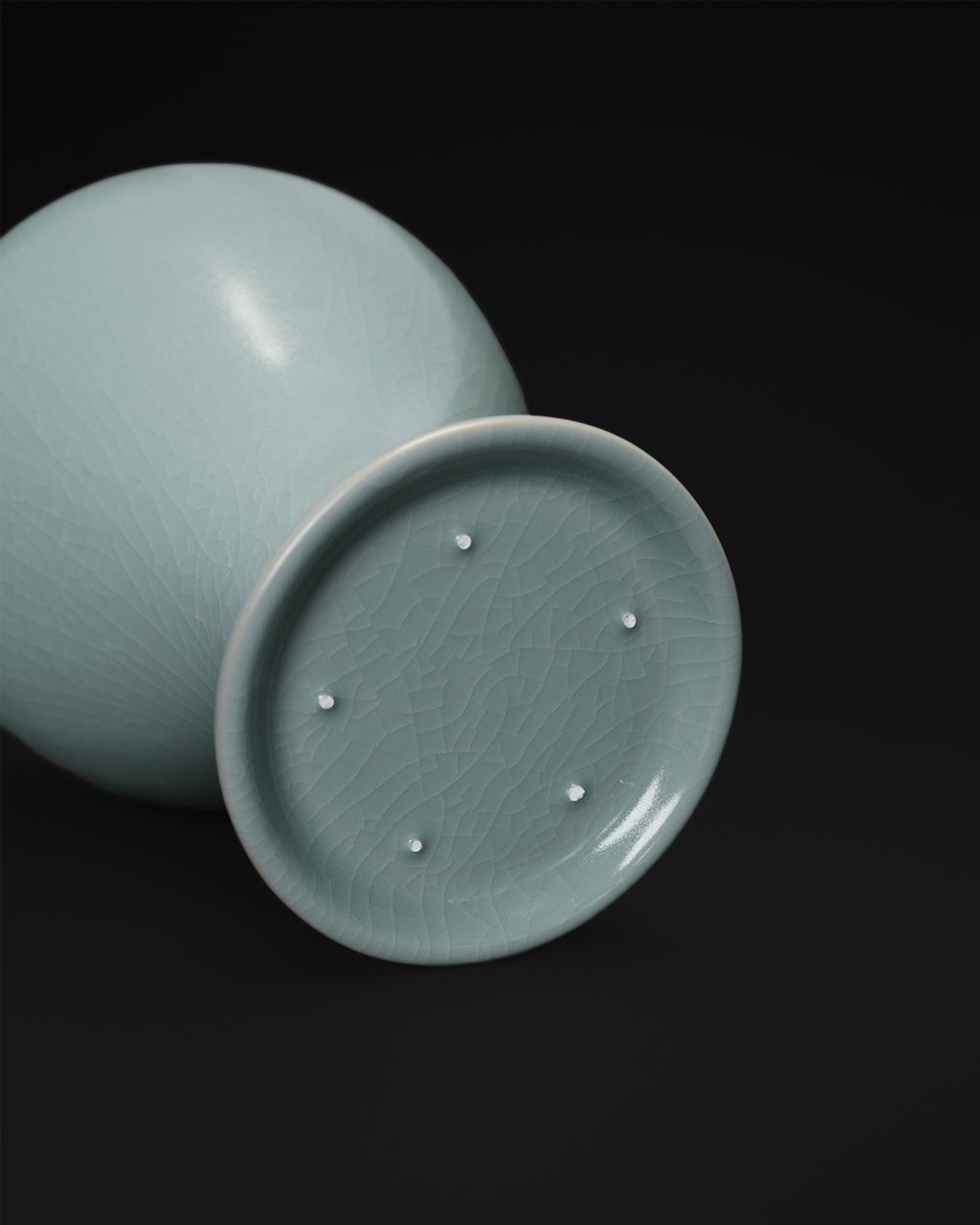 Base view of the celadon Meiping vase showing fine crackle and five visible spur marks.