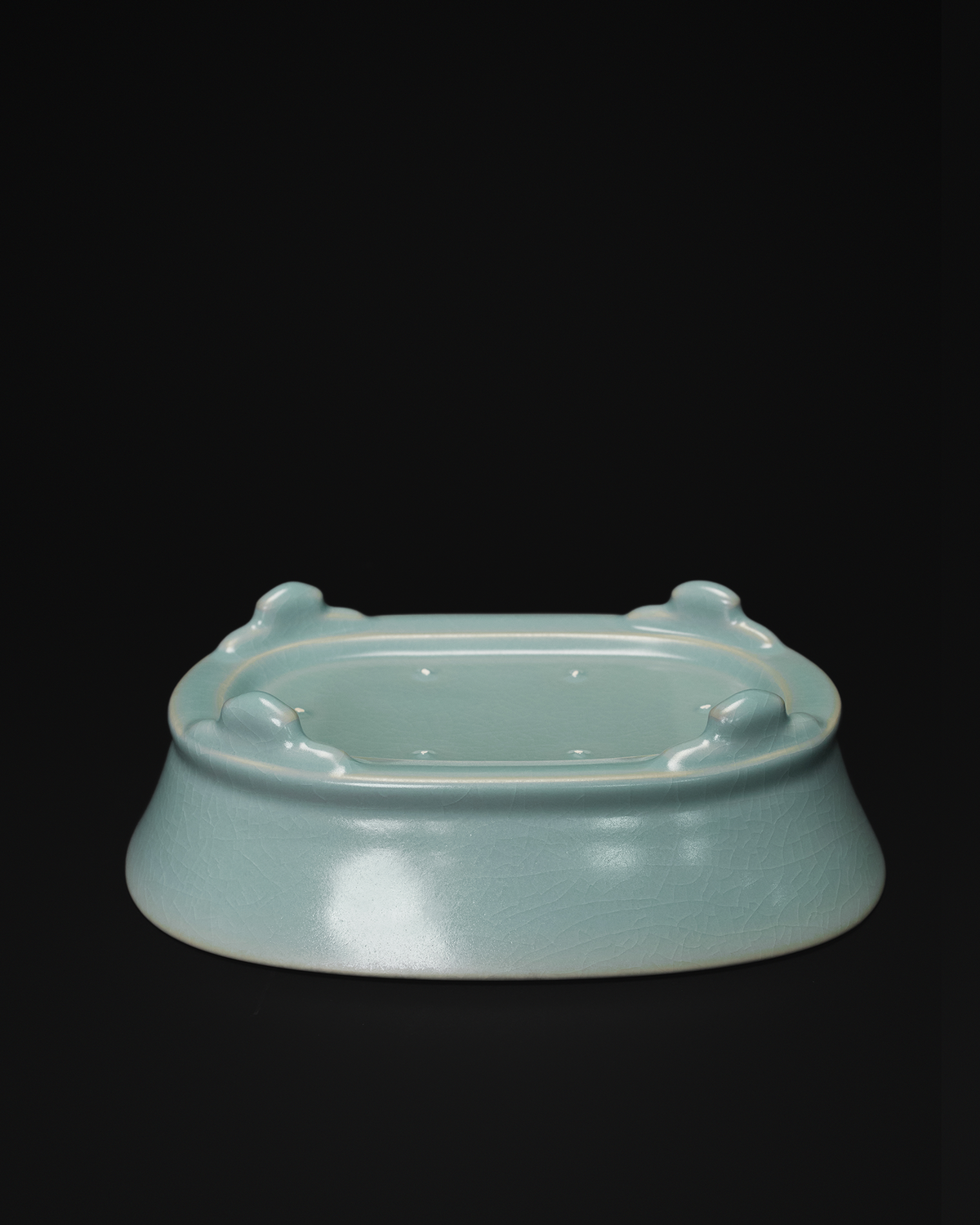 Underside view of the celadon narcissus basin showing its four raised feet and recessed base.