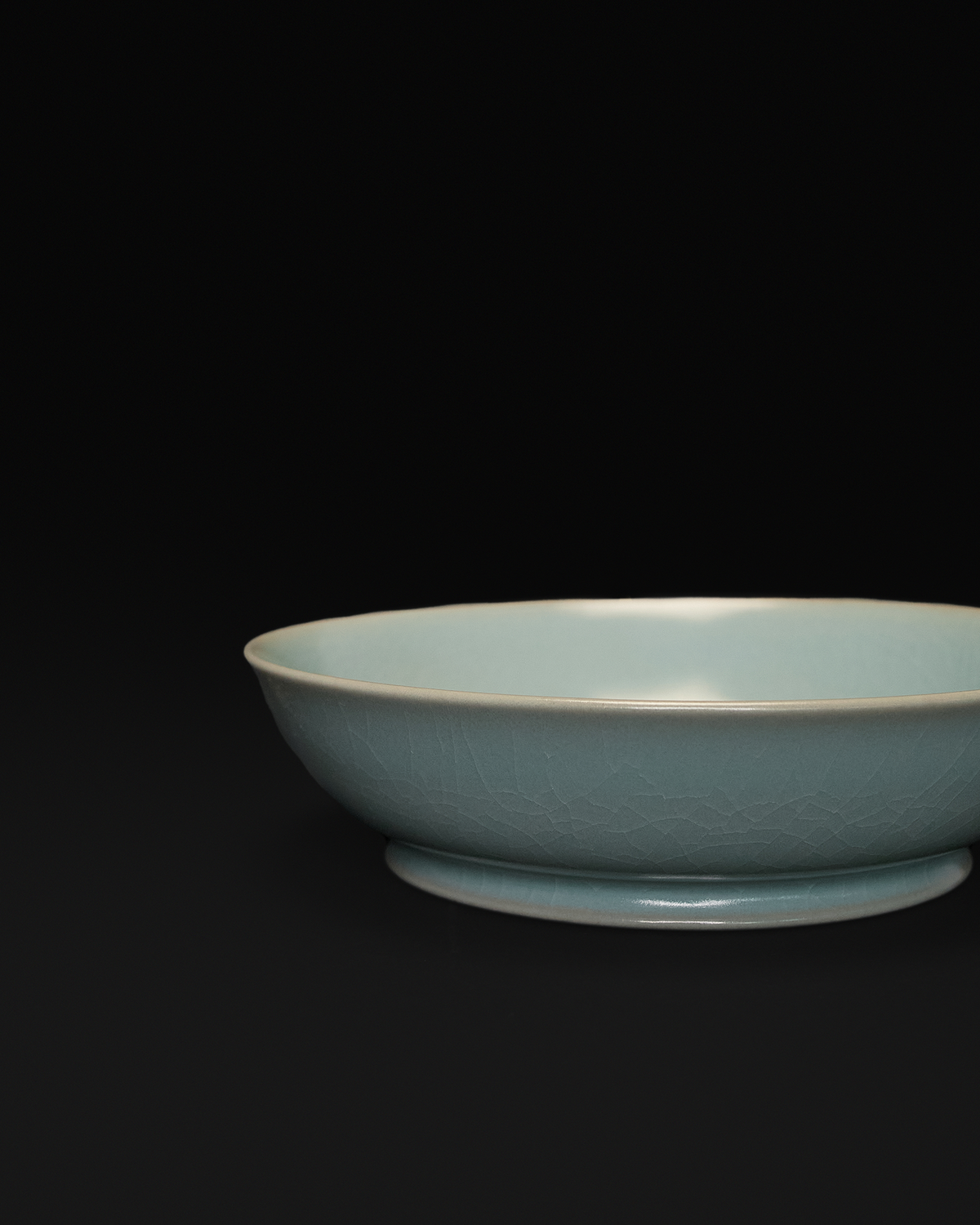 Close-up of the crackle celadon glaze, rounded rim and shallow profile of the brush washer.