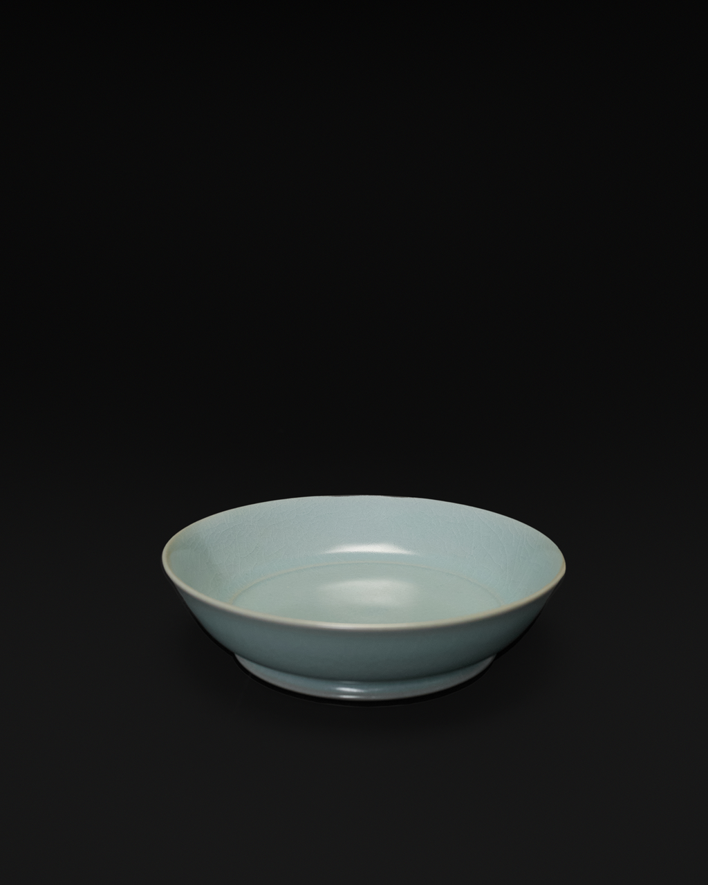 Three-quarter view of the Ru ware brush washer showing its shallow bowl and low foot ring.
