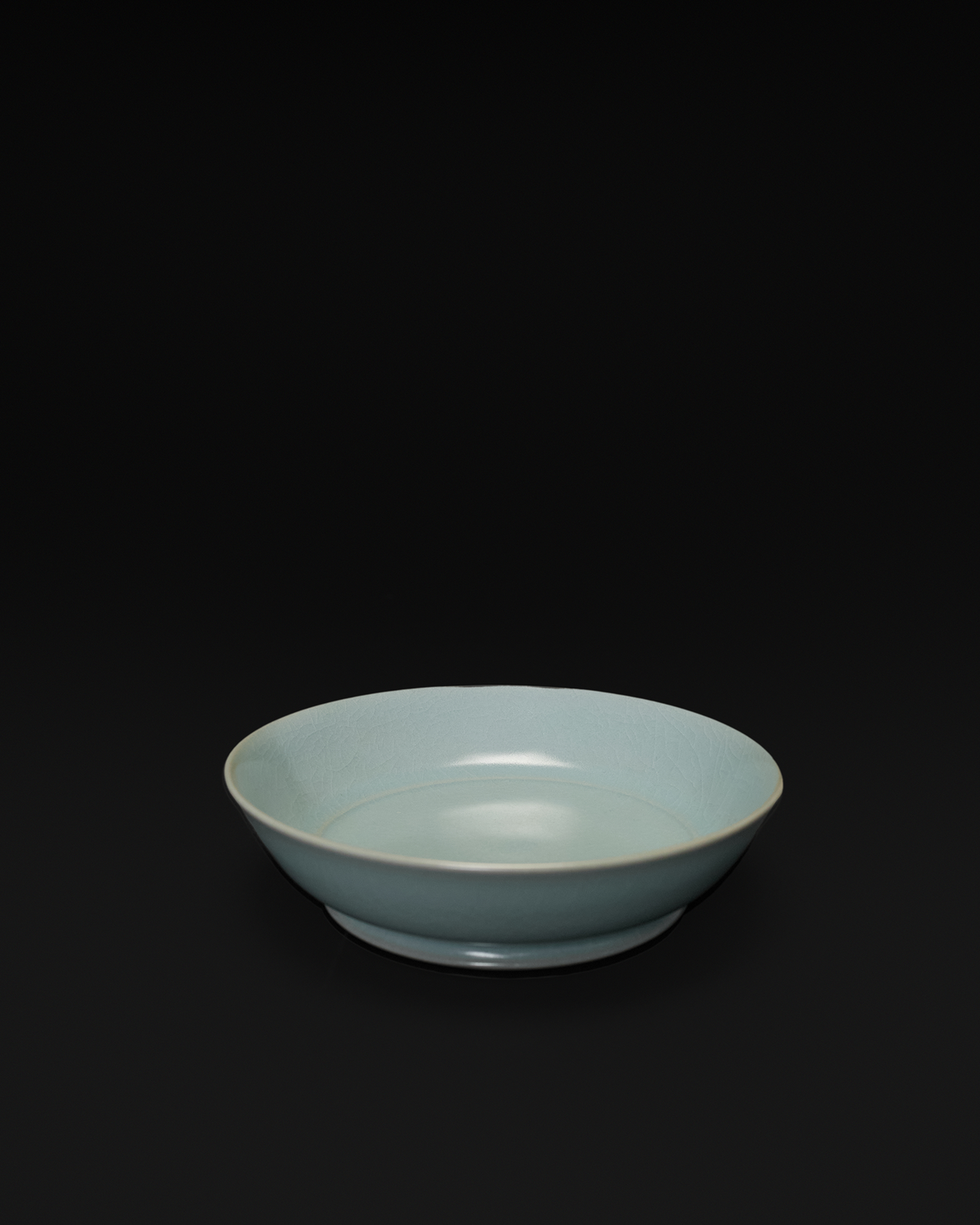 Three-quarter view of the Ru ware brush washer showing its shallow bowl and low foot ring.