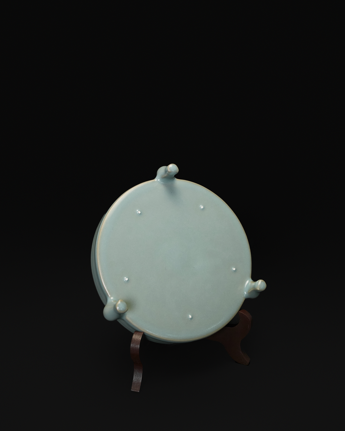 Underside view of the tripod bowl showing all three feet and visible firing spur marks.